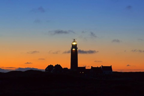 Eierland Lighthouse in the dunes silhouetted against sunset on the northernmost tip of the Dutch island of Texel