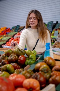 Portrait of a caucasian woman buying vegetables and greens in the grocery store