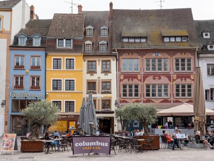 Medieval building with tables in the restaurant around the Place de la Reunion