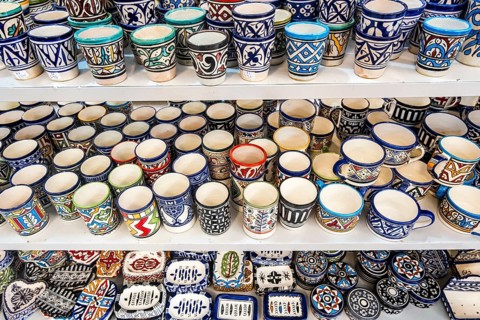 Shelves full of handmade ceramic products in pottery factory in Fez