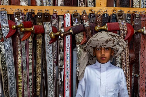 Traditional dressed boy in a Store for daqggers or Jambiya
