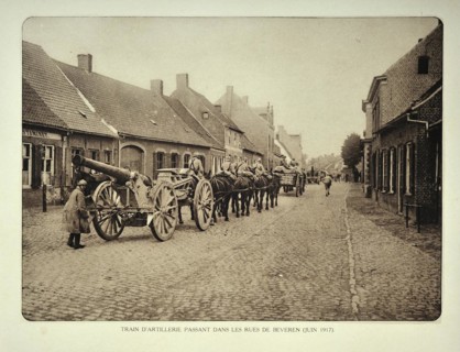 Artillery soldiers transporting cannons by horse through the village Beveren in Flanders during the First World War