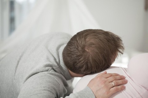 Man listening to the belly of a pregnant woman