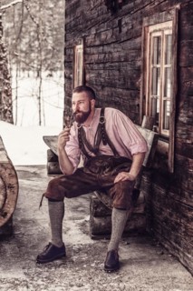 Bavarian man with lederhosen and pipe in hand