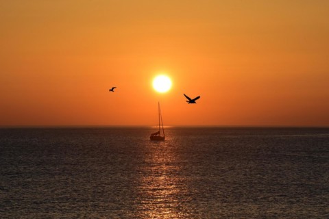 Sunset with sailboat on the Atlantic Ocean in Normandy