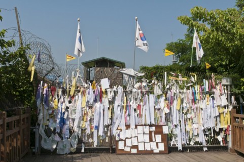 Messages and flags pinned to the barricade at the end of the Freedom Bridge within the Demilitarized Zone