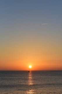 Sunset with sailboat on the Atlantic Ocean in Normandy