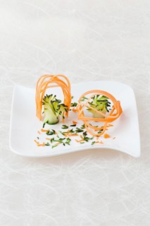 White plate decorated with carving of yellow beetroot and courgette
