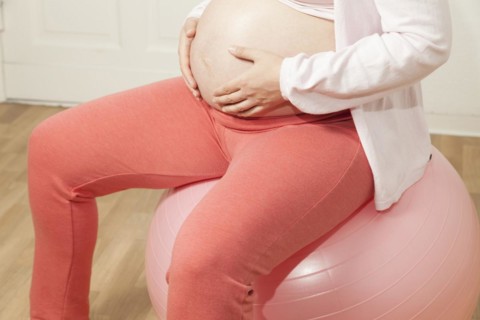 Pregnant woman sitting on an exercise ball