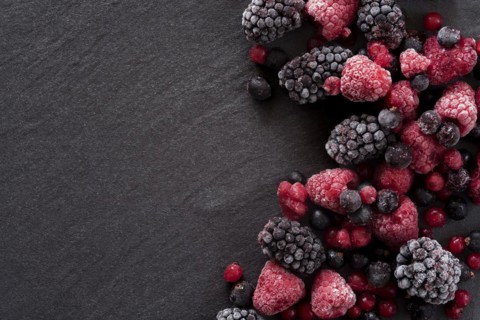 Frozen summer berries on a slate background