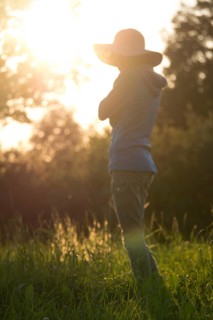 Young woman with hat relaxing in summer sunset sky outdoor