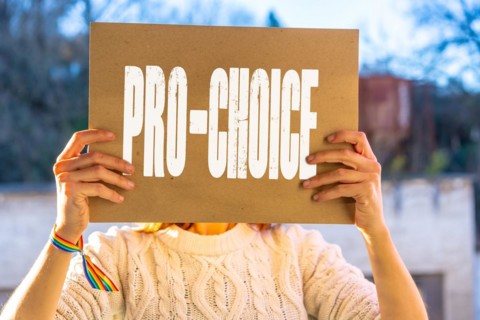 A woman holding a poster in her hands in favor of the legalization of abortion