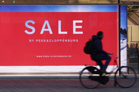 Illuminated shop window with poster Sale