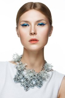 Beautiful fashionable girl with smooth hair and original decoration around her neck