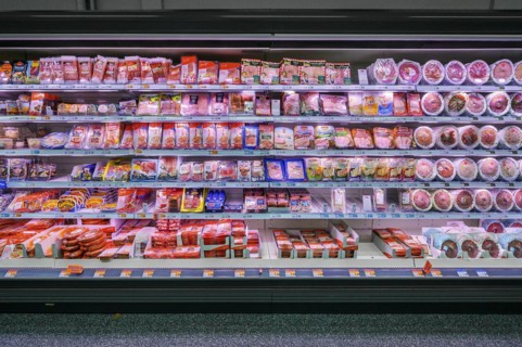 Shelf with sausages packed in plastic in a wholesale market