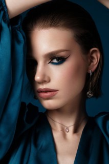 Beautiful woman with blue fabric and classic arrows art make-up