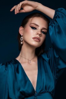 Beautiful woman with blue fabric and classic arrows art make-up