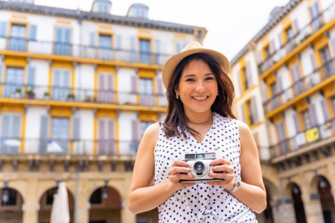 Tourist woman enjoying visiting the city looking at camera