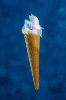 Colored cotton balls in various containers on a blue background