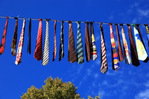 Many colourful ties hanging on a clothesline