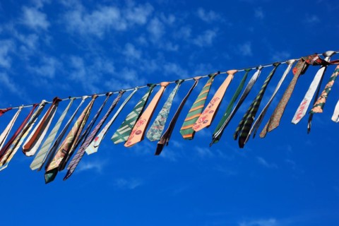 Many colourful ties hanging on a clothesline