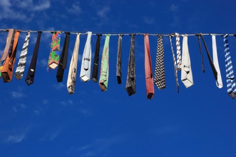 Many colourful ties hanging on a clothesline