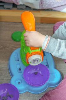 Unrecognizable child playing with a plasticine toy on the floor of his bedroom
