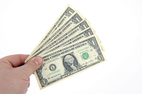 One dollar banknotes held as fans in one hand