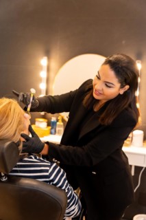 Latin ethnic woman in a beauty shop working with the client's eyebrows