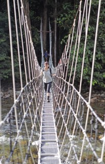 Woman crossing a suspension bridge