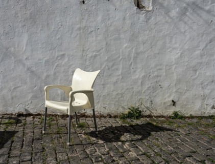 White plastic chair in front of old house facade