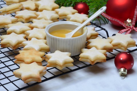 Christmas biscuits on cake rack and tray with lemon curd