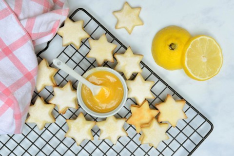 Christmas biscuits on cake rack and tray with lemon curd
