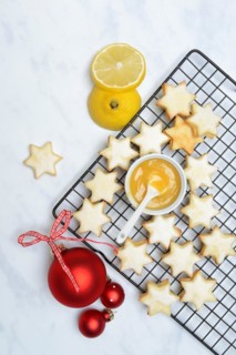 Christmas biscuits on cake rack and tray with lemon curd