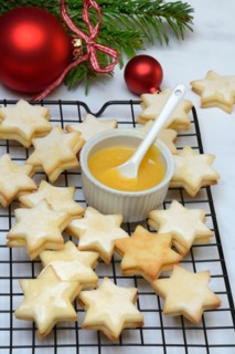 Christmas biscuits on cake rack and tray with lemon curd