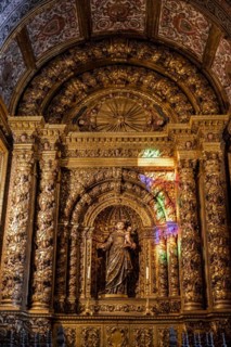Coloured light shines on statue of saint