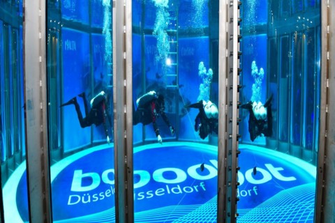 Diver in new diving tower in exhibition hall of water sports fair boot
