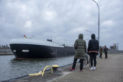 Onlookers look at a newly built tanker