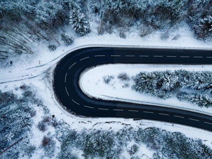 Aerial view of an S-curve in the forest with snow