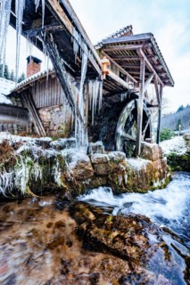 Water mill in snow and ice in winter
