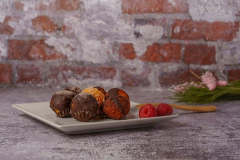 Sweet truffles of different flavors on a white ceramic plate