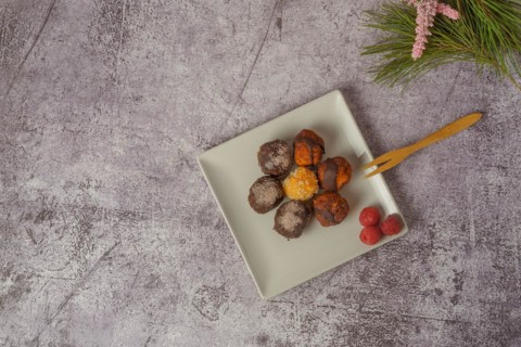 Sweet truffles of different flavors on a white ceramic plate