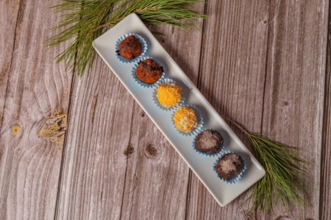 Sweet truffles in different flavors on a white ceramic tray