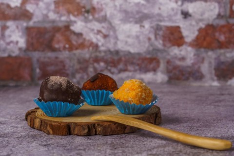 Truffles of different flavors on a wooden disk