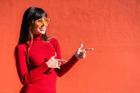 Brunette girl in a spring orange dress and sunglasses