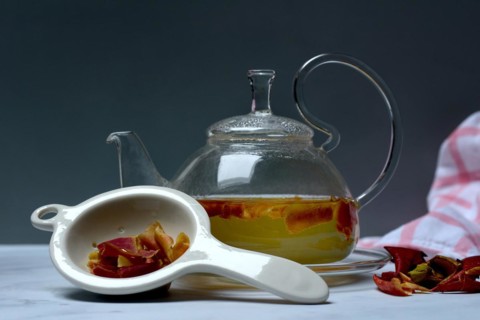 Apple peel tea in teapot and apple peel in tea strainer
