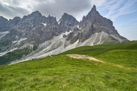 Green alpine meadows with mountain panorama