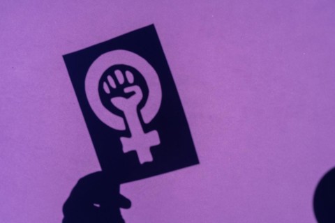 Shadow of the symbol of the fight for feminism on a purple background