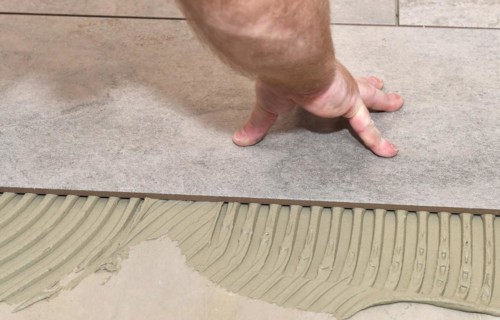 Tiler lays tiles on the floor