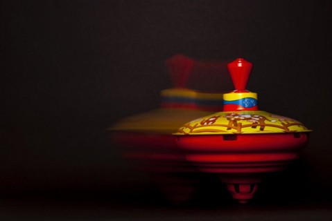 Spinning and moving humming top against a black background
